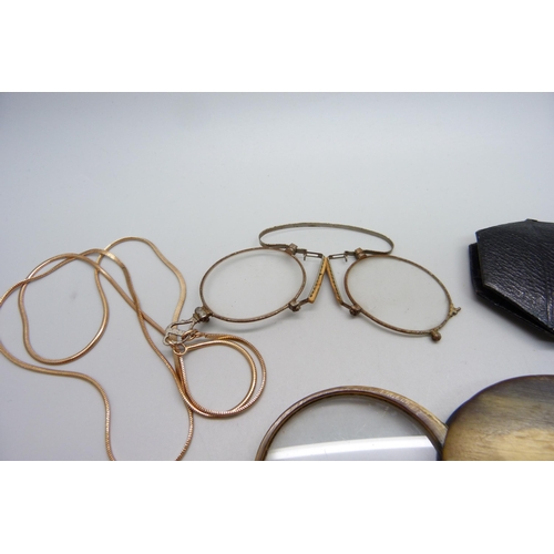 1020 - A Georgian horn mounted magnifying glass and a pair of Victorian pince-nez on a gold tone chain