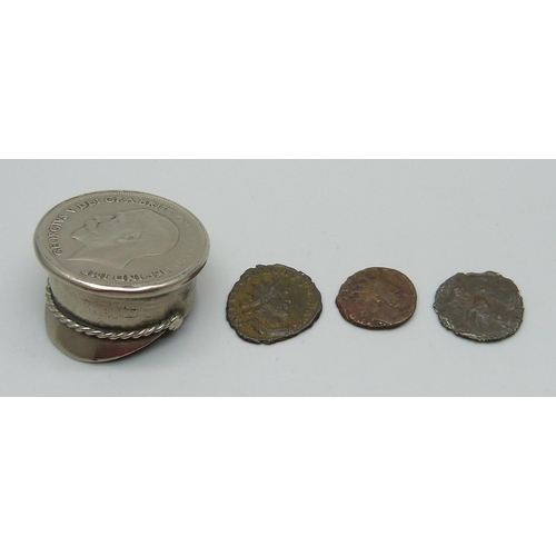 1069 - A small novelty peaked cap set with a one penny coin and three Roman coins