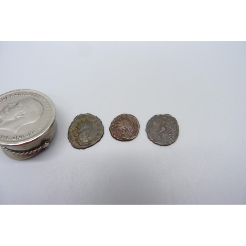 1069 - A small novelty peaked cap set with a one penny coin and three Roman coins