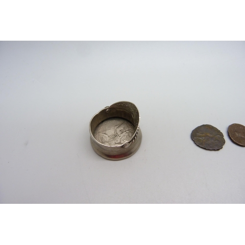 1069 - A small novelty peaked cap set with a one penny coin and three Roman coins