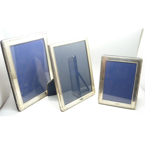 1075 - Three silver photograph frames, heights 15.5cm, 20.5cm and 21cm