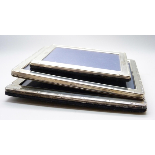 1075 - Three silver photograph frames, heights 15.5cm, 20.5cm and 21cm