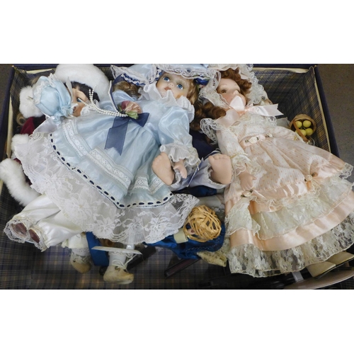 1124 - A box of modern porcelain dolls with display stands and one boxed baby crawling doll in a blue case ... 