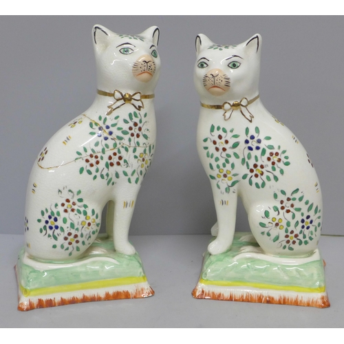 608 - A pair of Staffordshire cats, decorated with enamel paints, a/f, 18cm