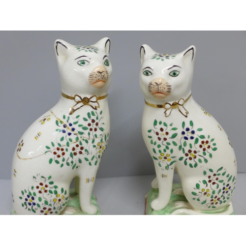 608 - A pair of Staffordshire cats, decorated with enamel paints, a/f, 18cm