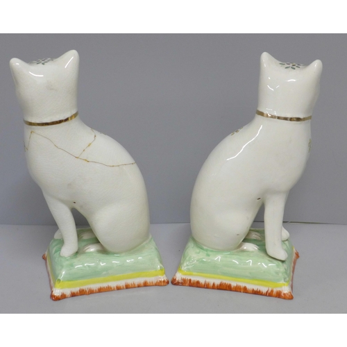 608 - A pair of Staffordshire cats, decorated with enamel paints, a/f, 18cm