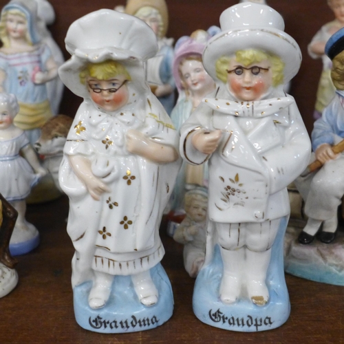 689 - A large collection of English and Continental porcelain and bisque figures, including three children... 