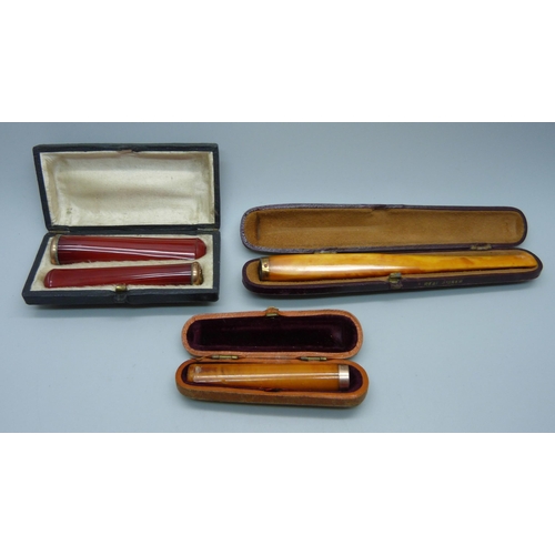 870 - Two amber cheroot holders, smallest with 9ct gold rims, and a set of two sherry amber cheroot holder... 