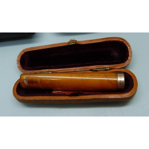 870 - Two amber cheroot holders, smallest with 9ct gold rims, and a set of two sherry amber cheroot holder... 