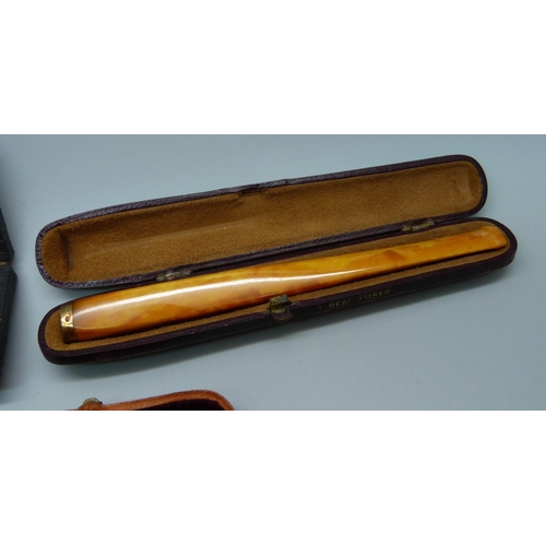 870 - Two amber cheroot holders, smallest with 9ct gold rims, and a set of two sherry amber cheroot holder... 