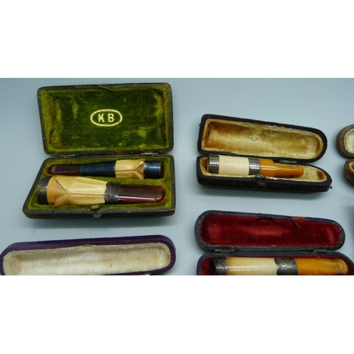 871 - Seven cheroot holders, with amber or sherry amber stems, six with sliver bands/rims, all cased