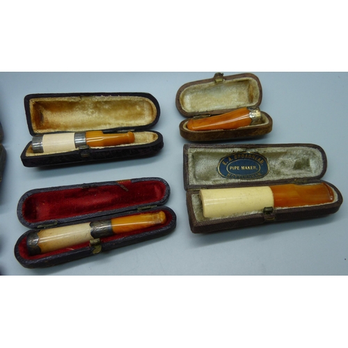 871 - Seven cheroot holders, with amber or sherry amber stems, six with sliver bands/rims, all cased