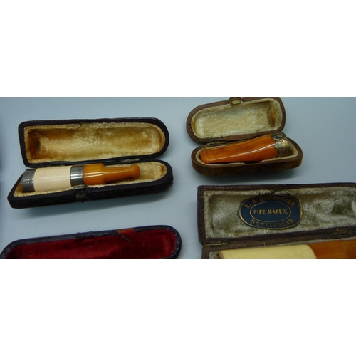 871 - Seven cheroot holders, with amber or sherry amber stems, six with sliver bands/rims, all cased