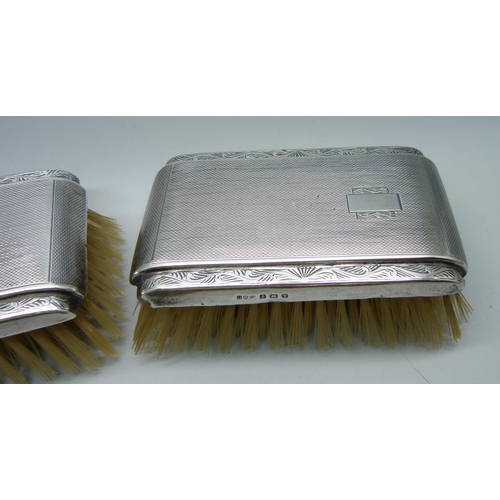 906 - Three silver backed brushes