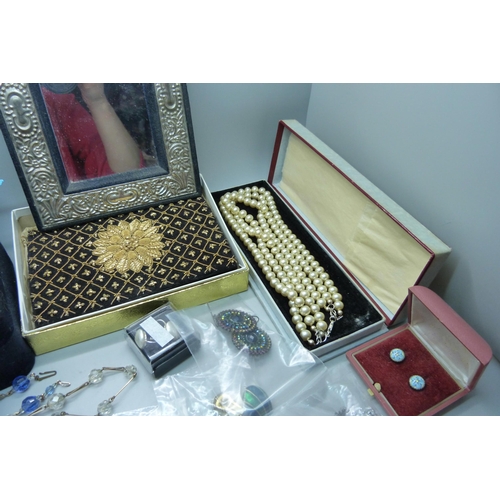 913 - Costume jewellery, necklaces and earrings, a jewellery box, a photograph frame, a purse and a candle... 