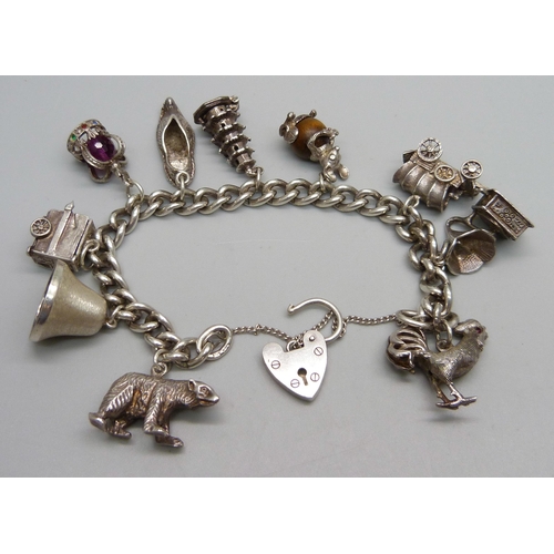 928 - A silver charm bracelet with ten silver charms, 63g