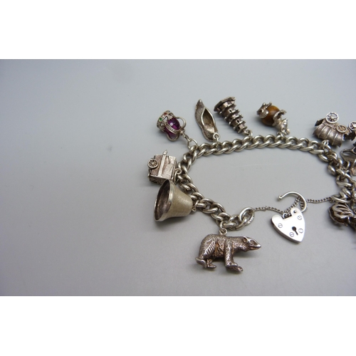 928 - A silver charm bracelet with ten silver charms, 63g