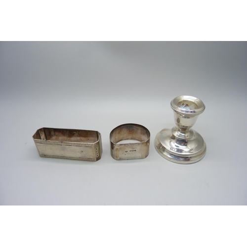 944 - Two silver napkin rings, 71g, and a small silver candlestick