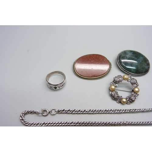 956 - A silver ring, a silver pendant, two stone set brooches, two silver brooches and a chain, (green sto... 