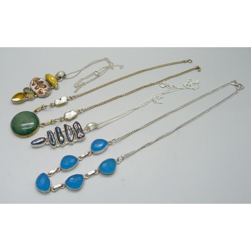 982 - Two silver pendants and chains, a white metal necklace and one other necklace