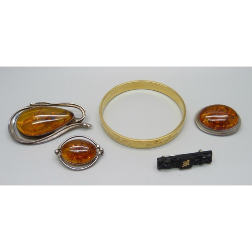 986 - Three amber set brooches, a jet brooch and a bangle