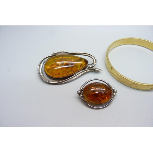 986 - Three amber set brooches, a jet brooch and a bangle