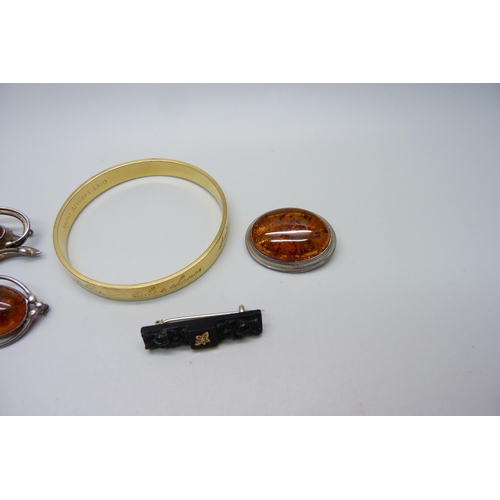 986 - Three amber set brooches, a jet brooch and a bangle