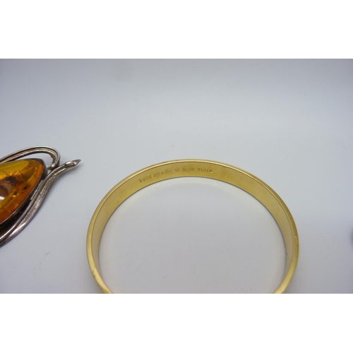 986 - Three amber set brooches, a jet brooch and a bangle