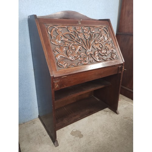 135 - An Arts and Crafts carved mahogany bureau