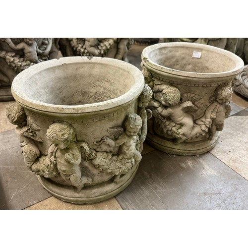 386 - A pair of small concrete planters decorated with cherubs