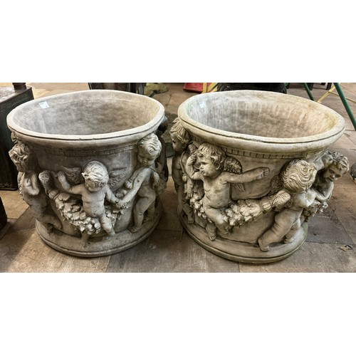 387 - A pair of large concrete planters decorated with cherubs