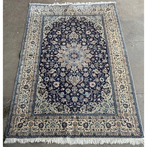 354 - A hand knotted cream and blue ground rug
234x137cm