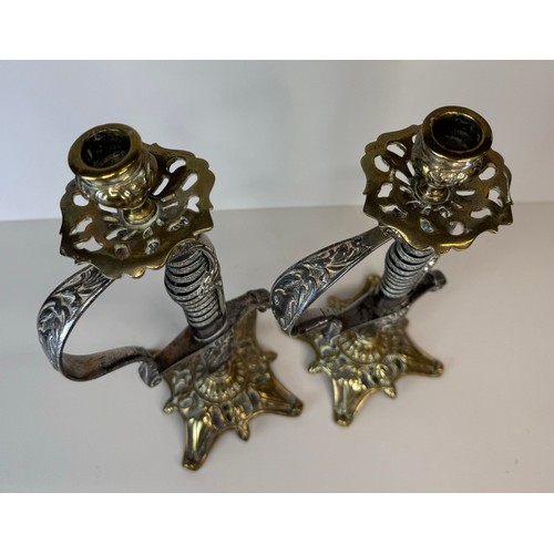 119 - A pair of brass mounted military sword handle candlesticks, 27cms h