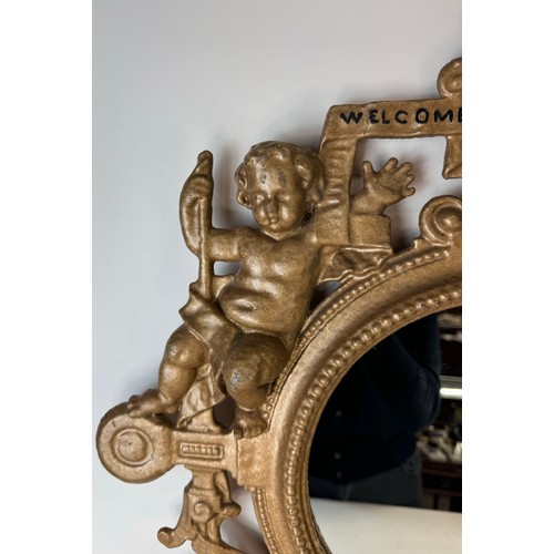 121 - A Victorian gilt metal framed mirror, cast with cherubs and inscribed; Welcome, Welcome, Thrice