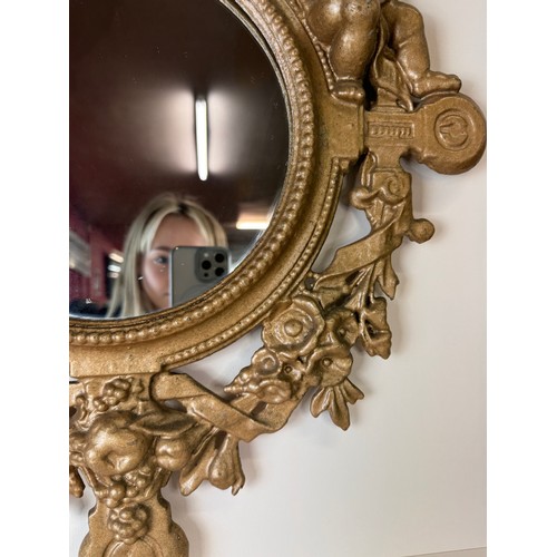 121 - A Victorian gilt metal framed mirror, cast with cherubs and inscribed; Welcome, Welcome, Thrice