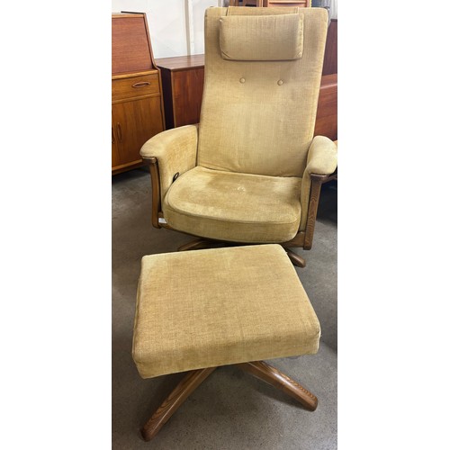 195 - An Ercol elm revolving armchair and footstool