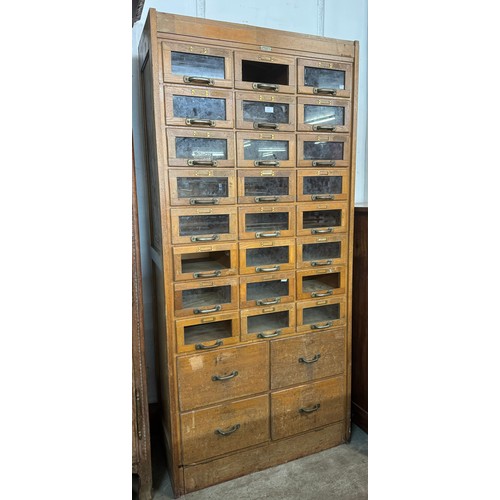 255 - An early/mid 20th Century oak haberdashery shop cabinet