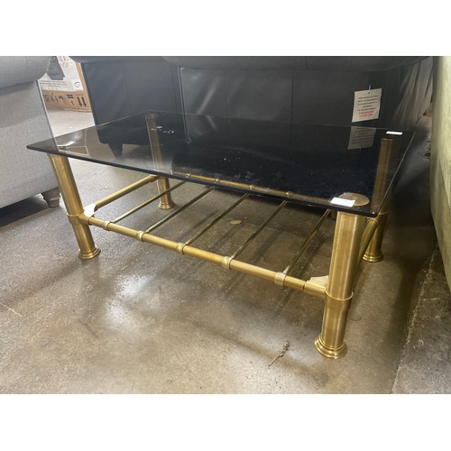 1505 - A glass coffee table with brass rack