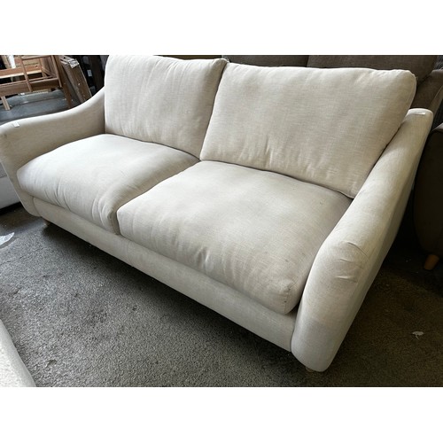 1543 - An off white upholstered three seater sofa