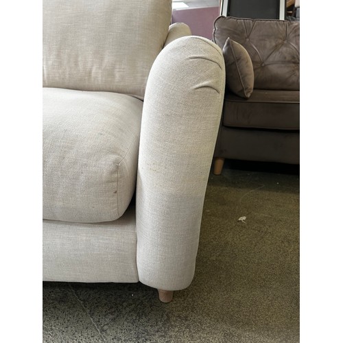 1543 - An off white upholstered three seater sofa