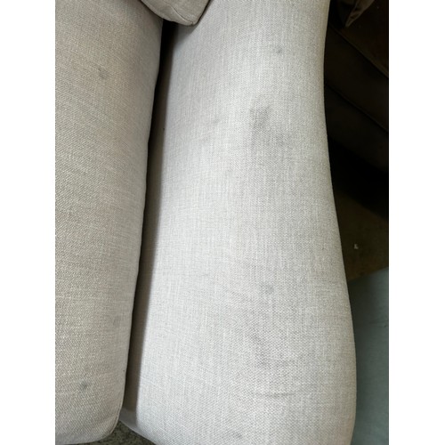 1543 - An off white upholstered three seater sofa