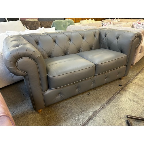 1545 - A dark grey leather Chesterfield two seater sofa