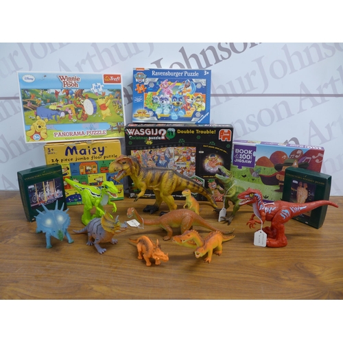 2216 - A box of 14 jigsaws mostly unused and all boxed and a large bag of various sized dinosaur toys