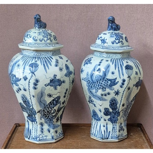 352 - A pair of Chinese blue and white octagonal stoneware lidded vases