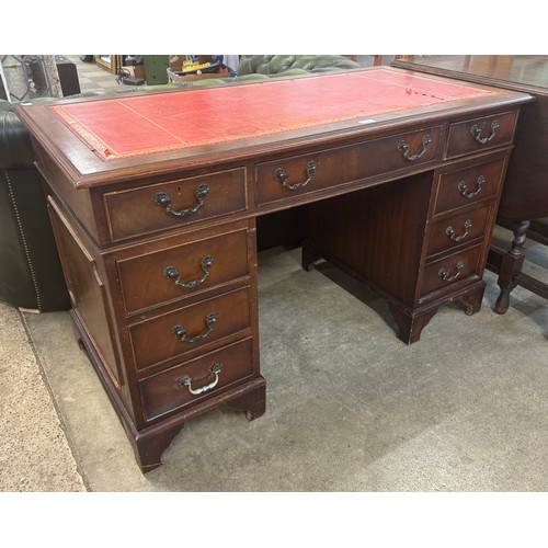 221 - A mahogany and red leather topped pedestal desk