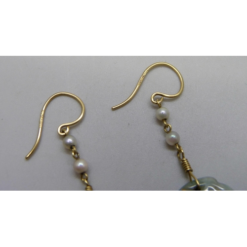 1033 - A pair of carved jade and pearl earrings on hallmarked 18ct gold wires, jade 18mm x 30mm