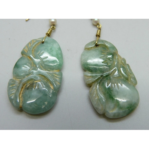 1033 - A pair of carved jade and pearl earrings on hallmarked 18ct gold wires, jade 18mm x 30mm