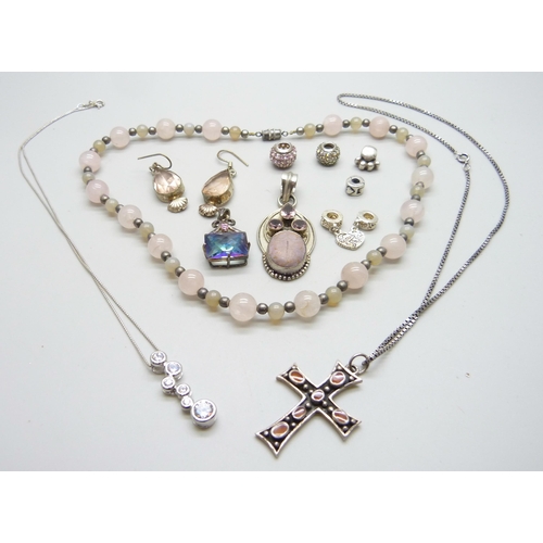 1053 - A rose quartz necklace, a silver cross pendant and chain, charms, etc.