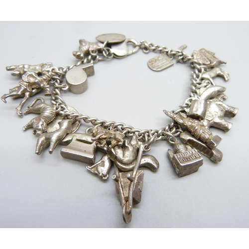 1068 - A silver charm bracelet, with approximately 26 silver and white metal charms, 94.1g