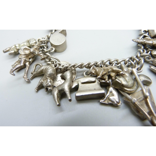 1068 - A silver charm bracelet, with approximately 26 silver and white metal charms, 94.1g